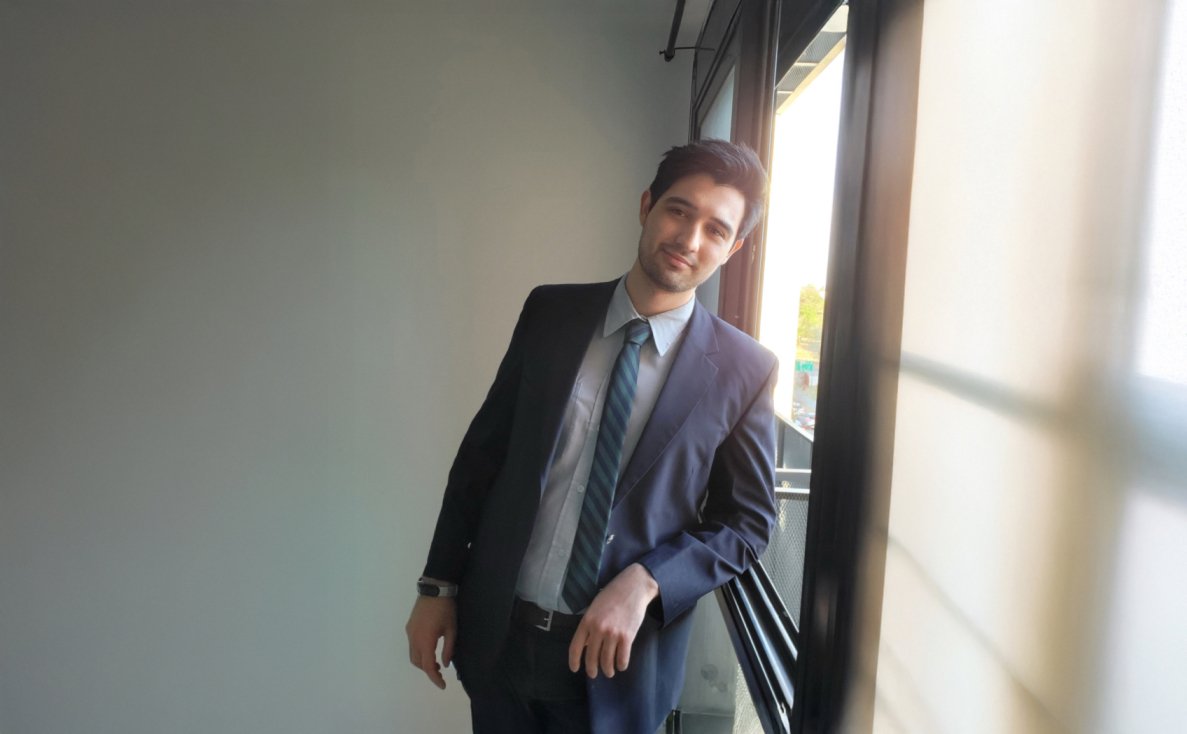 Gonzalo is standing in a window during an afternoon in the city